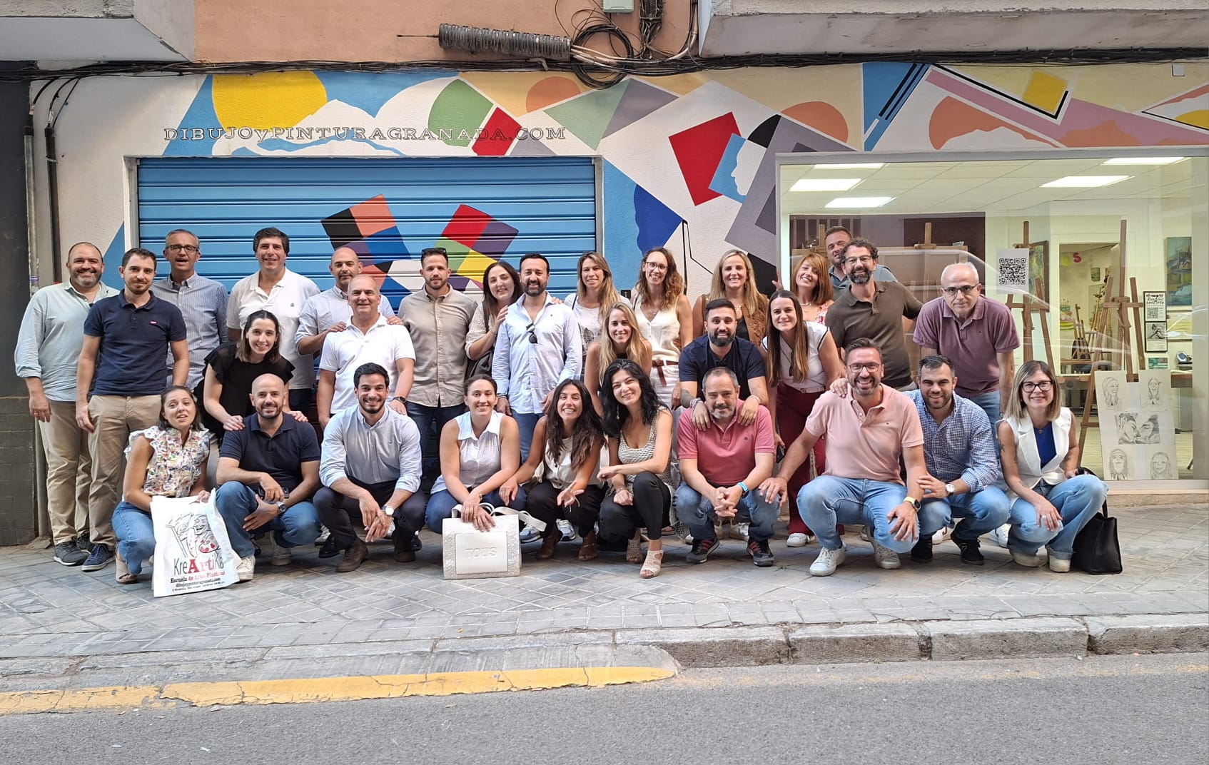 Equipo participando en un mural colaborativo de pintura creativa en Granada